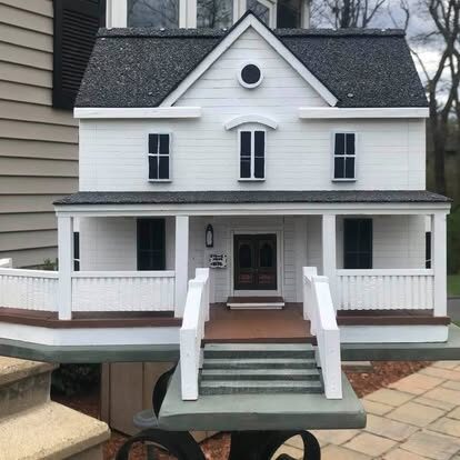 Home replica with detail including front porch and hot tub.